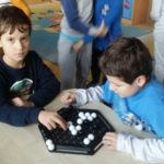 Dwoje uczniów przy stoliku gra w grę Abalone