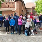 grupa uczniów pod murami zamku w Malborku