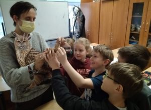 5 uczniów z klas drugich dotyka eksponatu sowy.