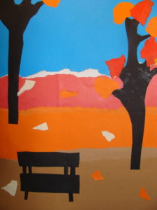 Praca na pierwszym planie przedstawia ławeczkę i po obu stronach drzewa. Całość w jesiennej scenerii kolorystycznej.