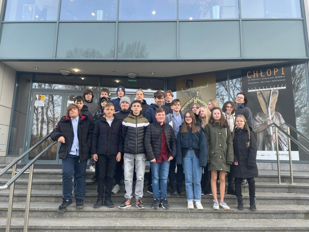 Grupa 22 uczniów stoi na schodach do Teatru Muzycznego w Gdyni