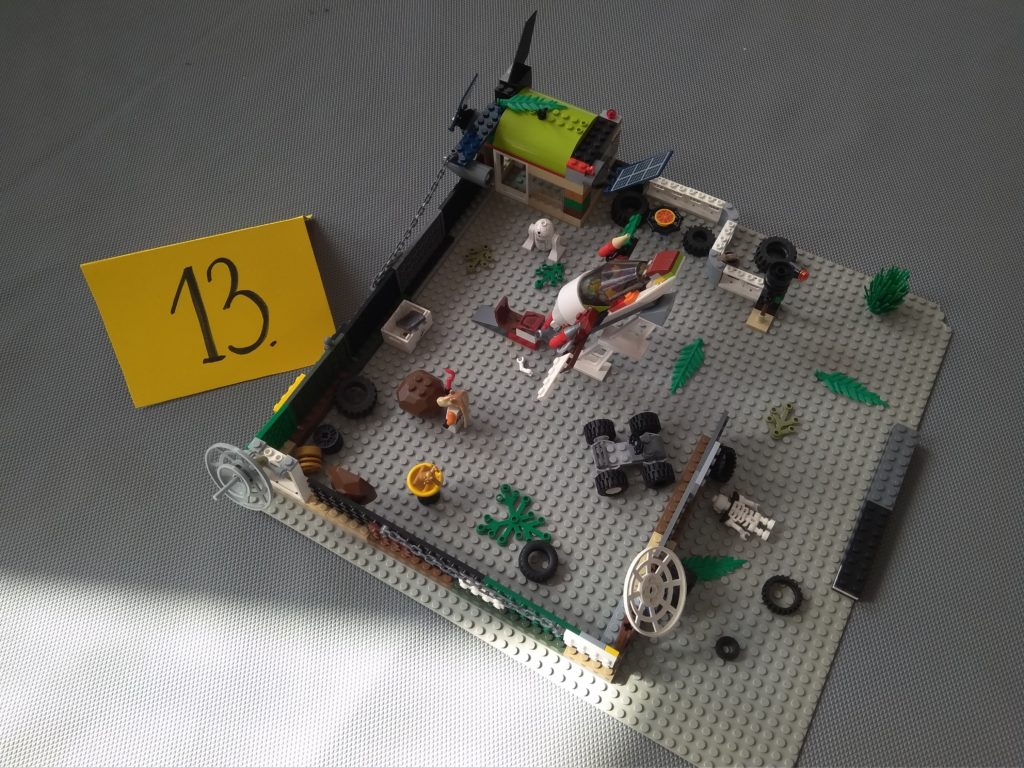 Na tle szarego materaca stoi konstrukcja z klocków LEGO przedstawiająca nowoczesną rakietę. 