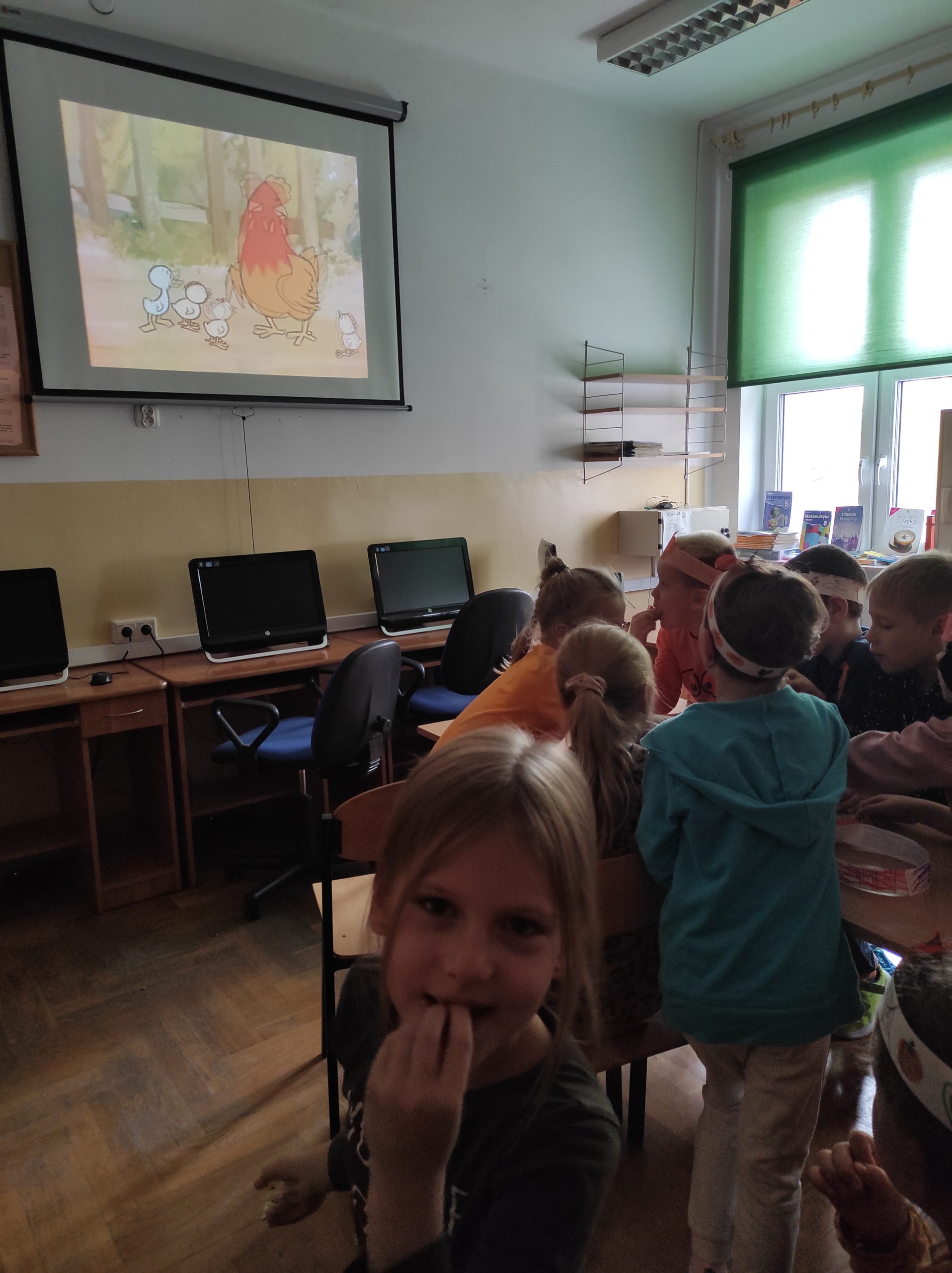 grupa dzieci na seansie filmowym w czytelni multimedialnej