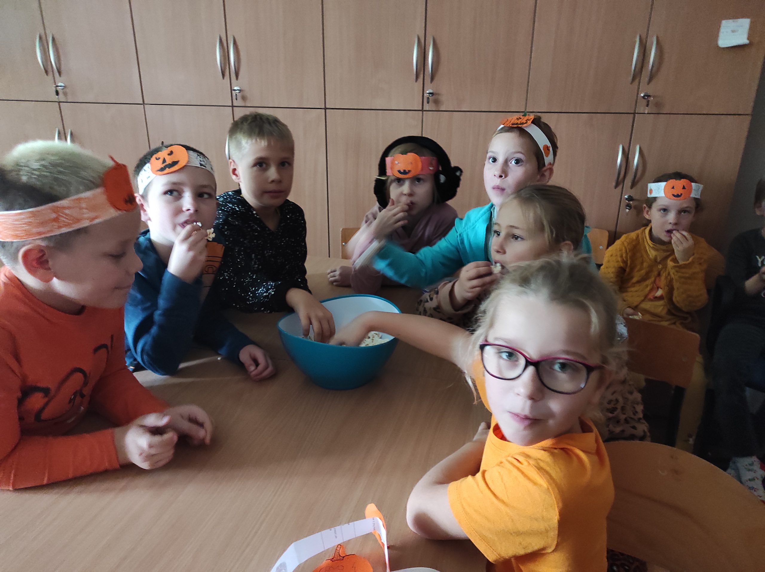 grupa dzieci jedząca popcorn na seansie filmowym w czytelni multimedialnej