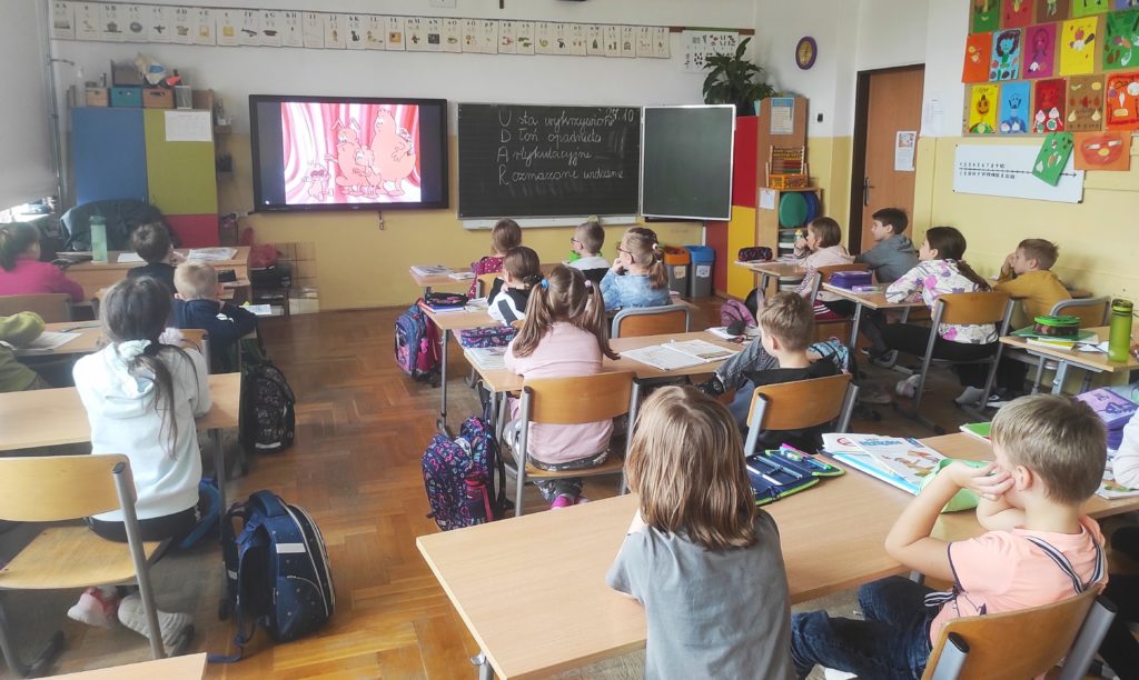 W sali lekcyjnej siedzą uczniowie klasy 2 obróceni przodem do tablicy multimedialnej, na której wyświetlony jest kadr filmu o mózgu.