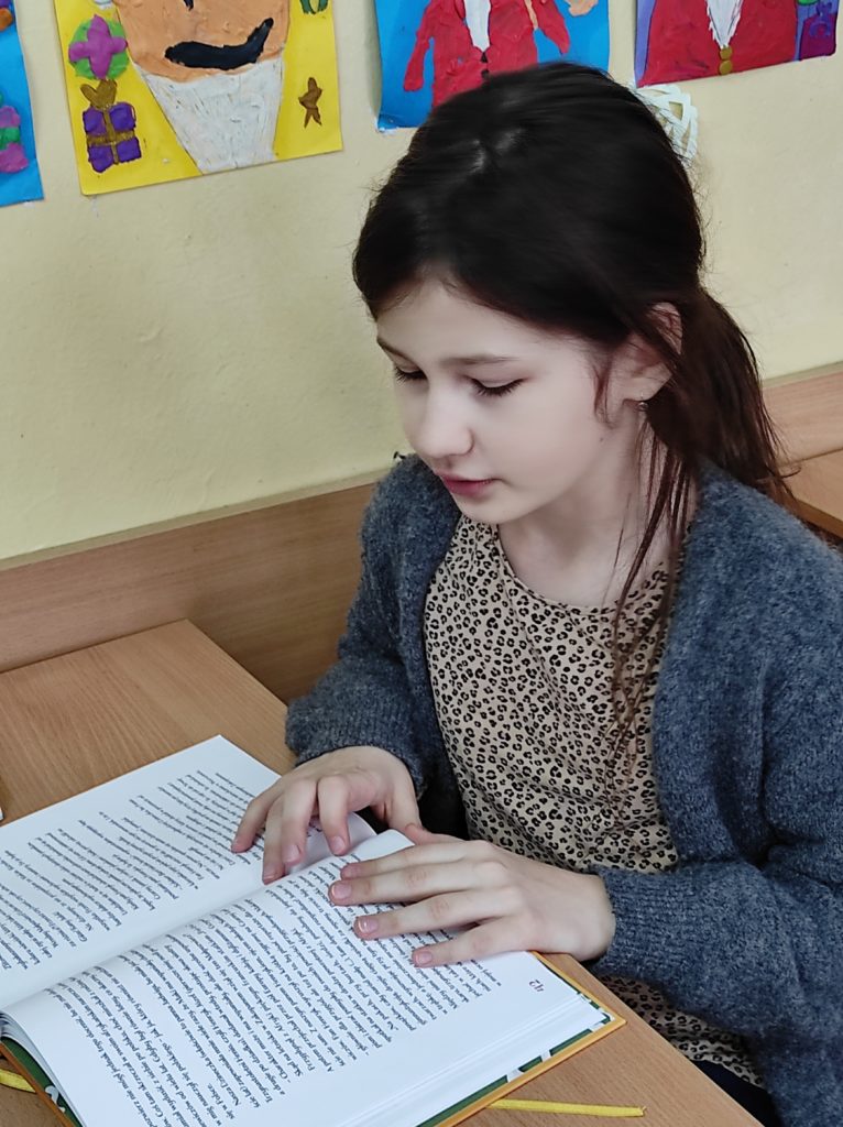 Dziewczynka czytająca ksiażkę podczas akcji Psss.. tu czyta klasa!