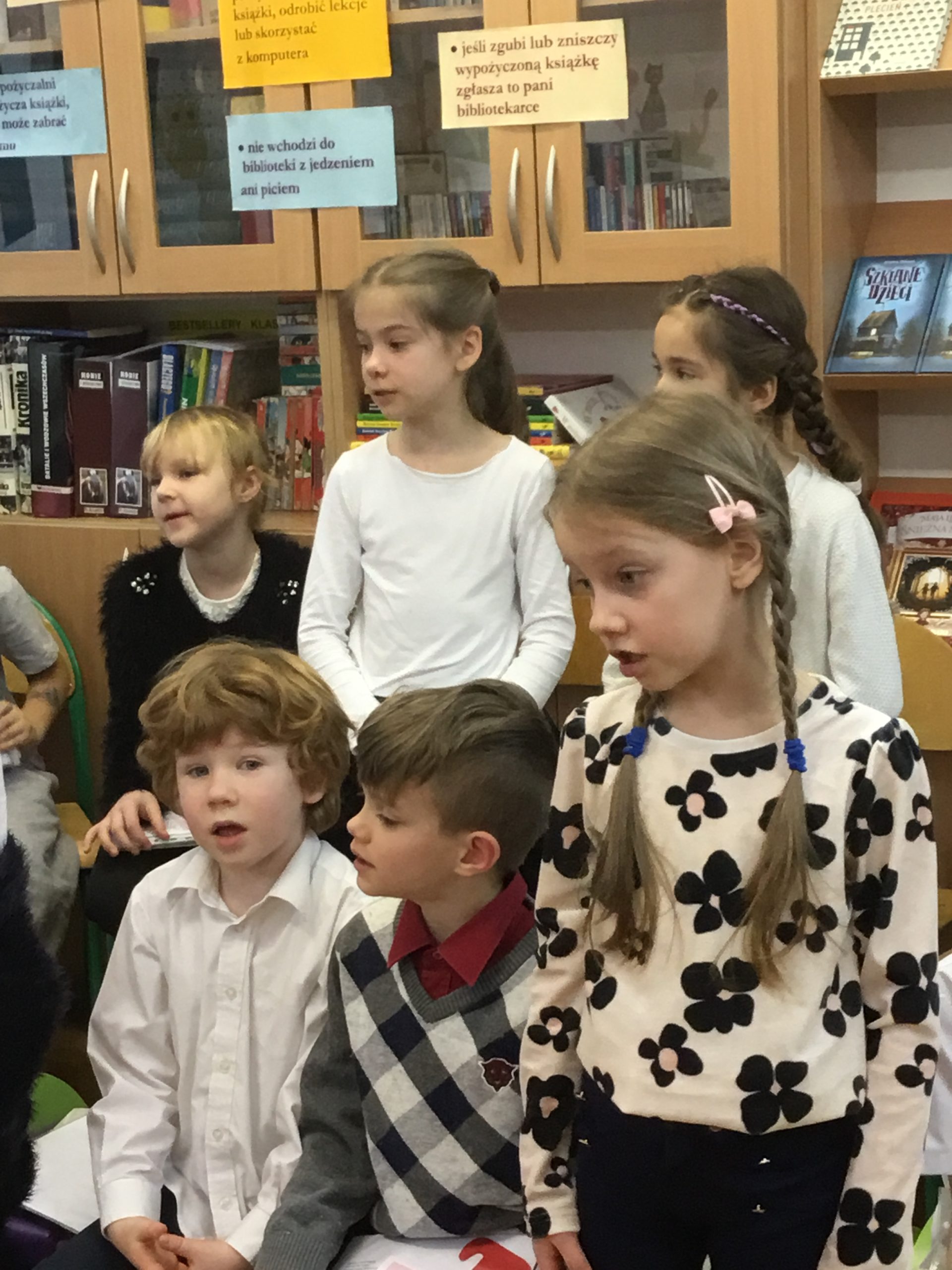 Grupa uczniów w bibliotece podczas Pasowania na Czytelnika
