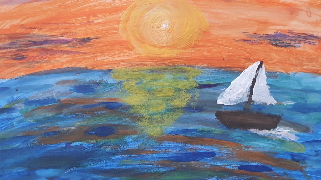 Na pierwszym planie błękitne morze, po prawej stronie żaglówka z białymi żaglami. Na linii horyzontu zachodzące słońce. Niebo w odcieniach pomarańczowej barwy