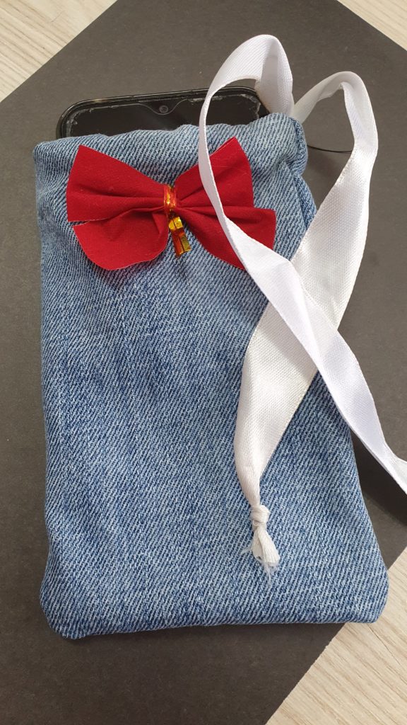 Dżinsowy woreczek z przyszytą czerwoną kokardką i wciągniętą białą wstążką