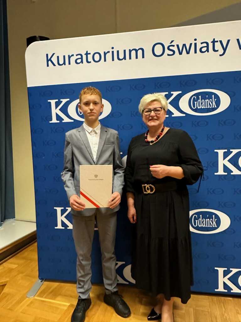 Pomorski Kurator Oświaty oraz uczeń, który odebrał dyplom Laureata Konkursu Wojewódzkiego