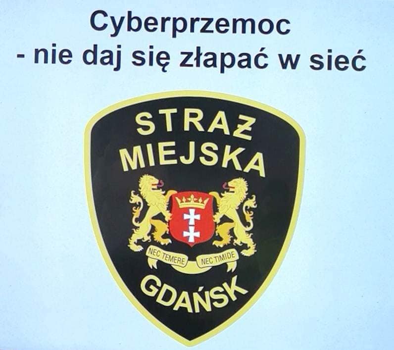 Na błękitnym tle jest logo Straży Miejskiej w Gdańsku. U góry zdjęcia jest czarny napis „Cyberprzemoc-nie daj się złapać w sieć”