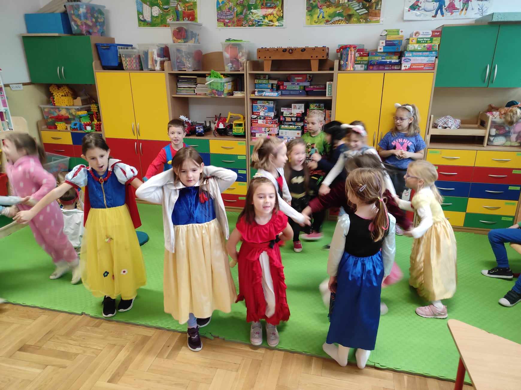 Ok. 15 dzieci tańczy w rytm muzyki.