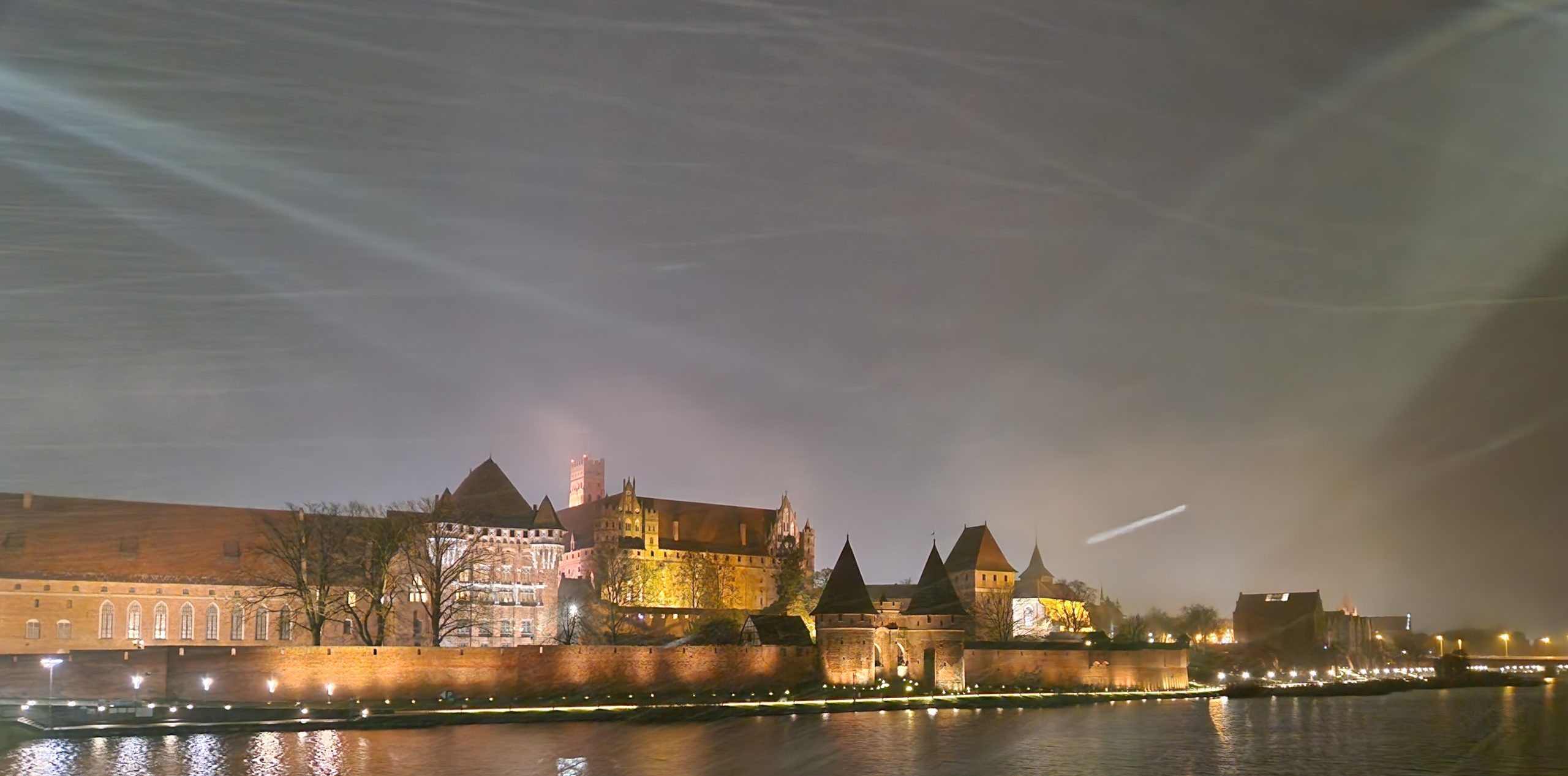 Zamek w Malborku oświetlony nocą.