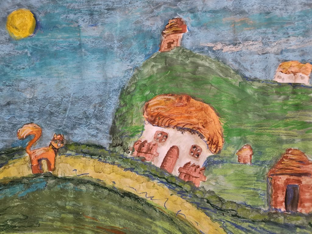 Praca przedstawia zielone górki z kotkiem oraz kolorowe domki
