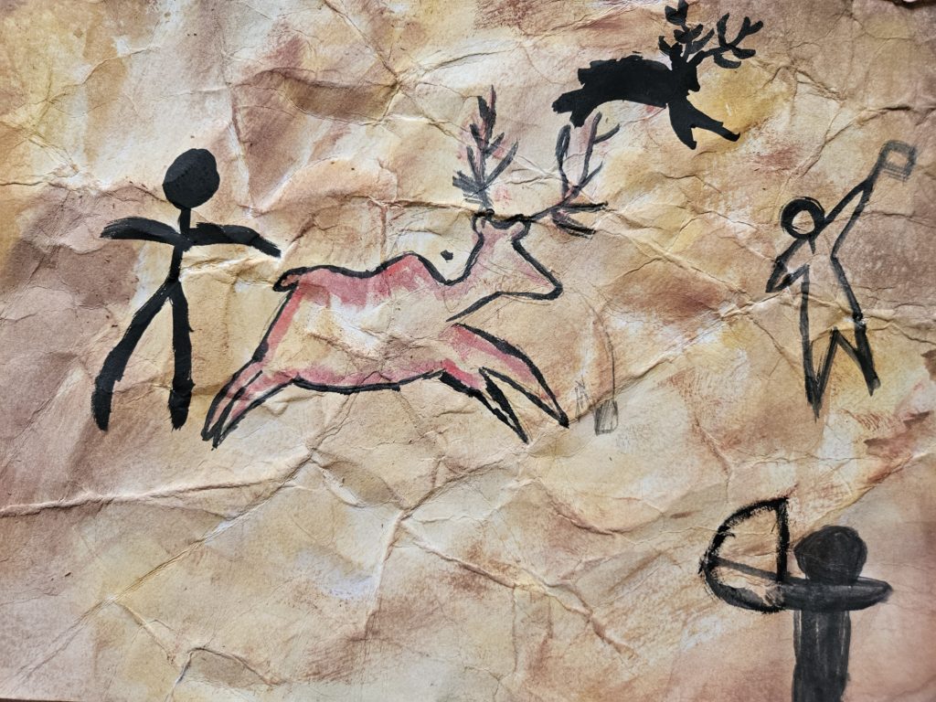 Praca inspirowana malarstwem paleolitu ze sceną z polowania. Na pierwszym planie zarys człowieka. Dalej kolejne postacie człowieka i uciekające jelenie