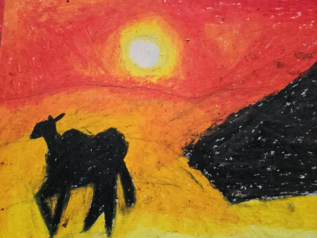 Na pierwszym planie czarne sylwetki to postać wielbłąda a po prawej stronie zarys piramidy. W tle pustynia. Na horyzoncie zachodzące słońce. Całość w gamie barw żótych i pomarańczowych