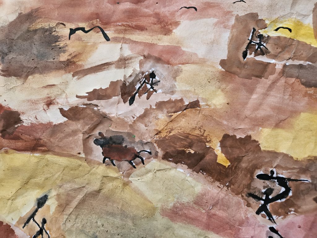 Praca inspirowana malarstwem paleolitu ze sceną z polowania. Na pierwszym planie, po lewej stronie zarysy uciekającego zwierzęcia, a po prawej goniących go ludzi. Na niebie czarne ptaki