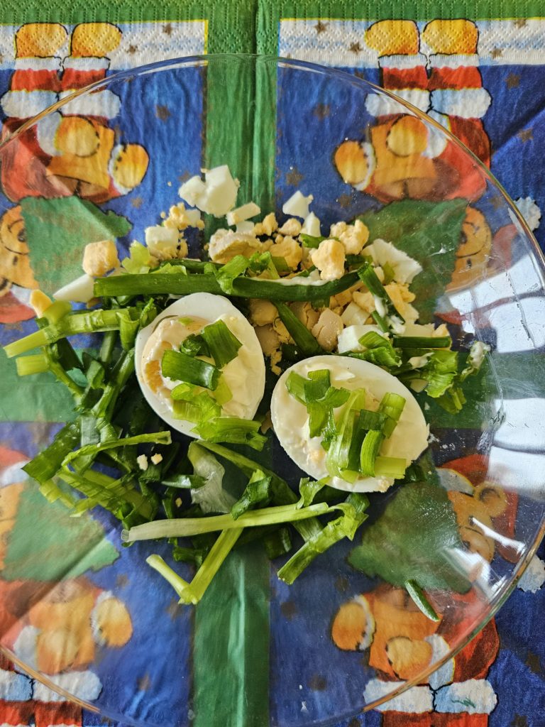 Na talerzykach ułożone i udekorowane warzywami ugotowane jajeczka