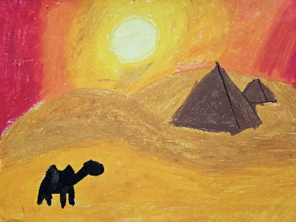 Na pierwszym planie sylwetka wielbłąda. w głębi zarys dwóch piramid