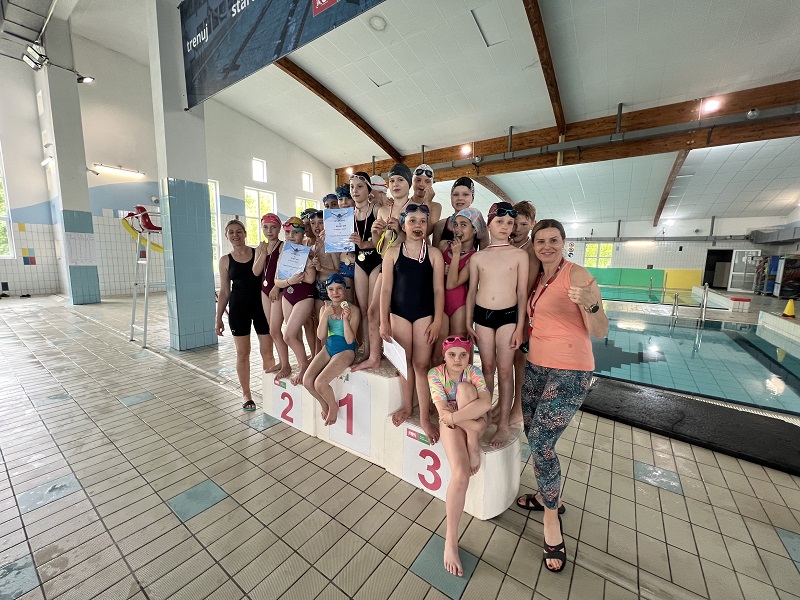 Po 5 uczniów ustawionych na trzech stopniach podium z medalami i pamiątkowymi dyplomami 