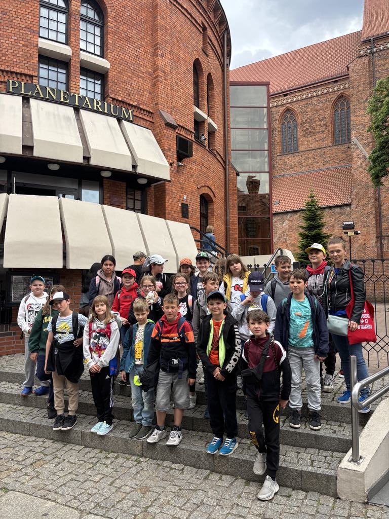 Klasa 3c stoi przed Planetarium w Toruniu.