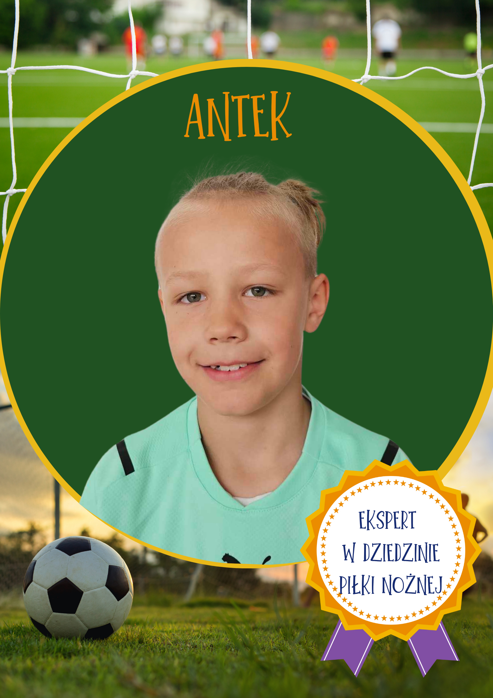 Chłopiec o blond włosach uśmiecha się do aparatu. Ma na sobie zieloną bluzkę piłkarską. Na zielonym tle widnieje napis 'Antek'. W prawym dolnym rogu znajduje się odznaka z napisem 'Ekspert w dziedzinie piłki nożnej'. 