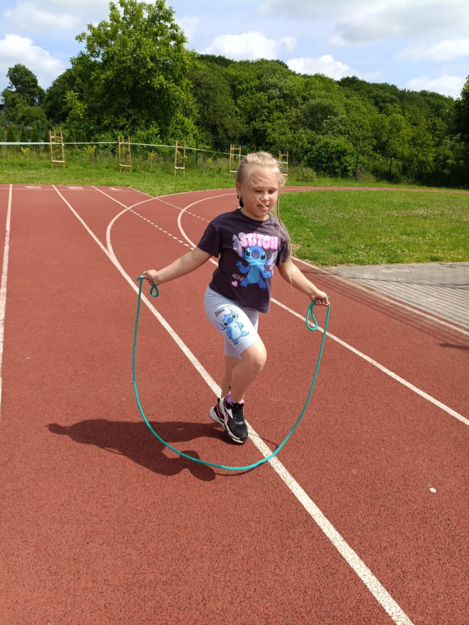 Dziewczynka skacze przez skakankę.