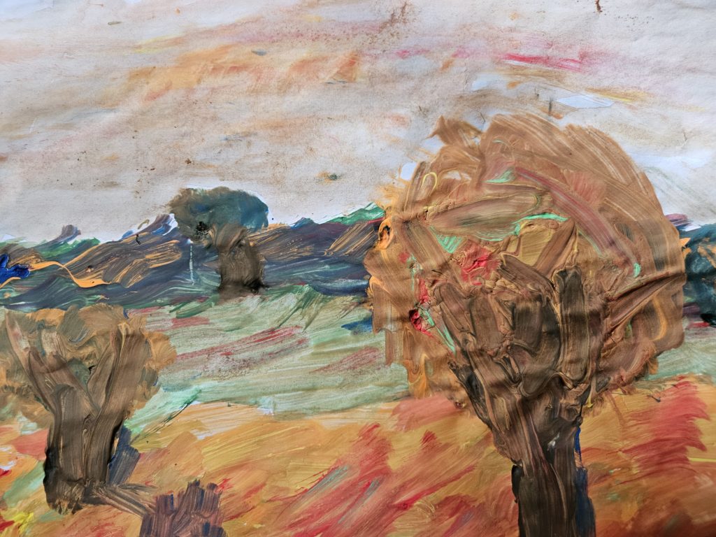 Praca przedstawia jesienny krajobraz z polami a na nich z pojedynczymi drzewami. Na pierwszym planie, po prawej stronie znajduje się duże drzewo zasypane żółto-pomarańczowymi liśćmi, na kolejnym planie pojedyncze drzewo