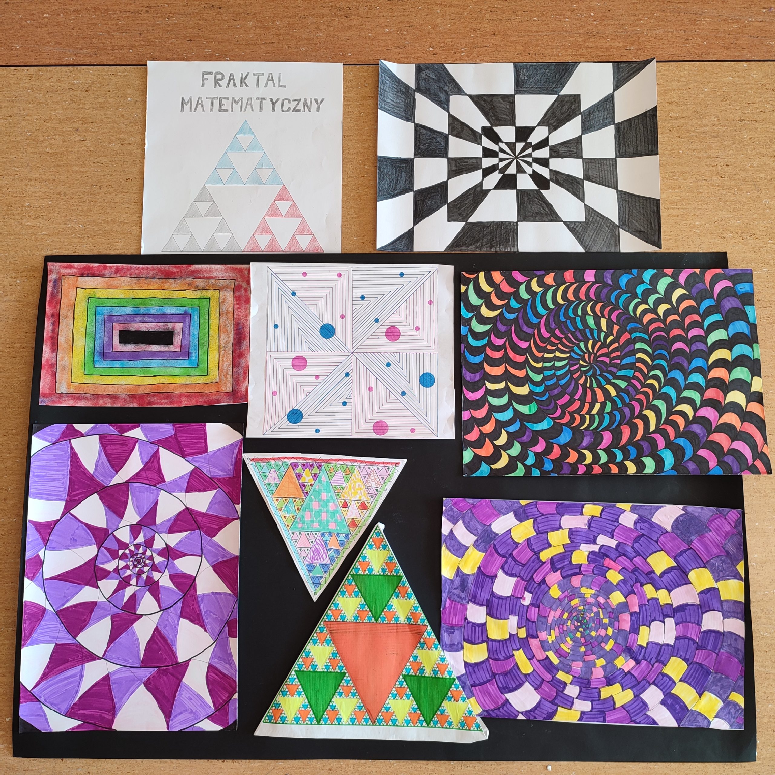 Ma fotografii położone są obok siebie prace uczniów przedstawiające fraktale matematyczne. Na kartkach są liczne kolorowe spirale oraz figury geometryczne.