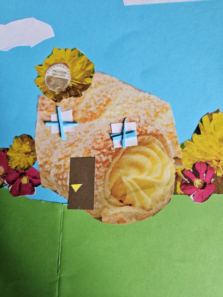 Na pracy w zieleni stoi budynek z drzwiami i oknami inspirowany kształtem rogala. Po bokach kwiaty