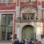 Uczniowie ustawieni w 3 rzędy, dwa stoją, jeden kuca. W tle fragment kamienicy.