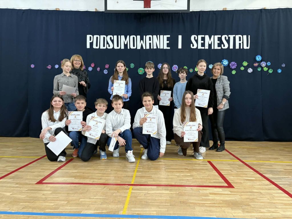 Na sali gimnastycznej stoi grupa wyróżnionych uczniów wraz z dyrekcją, wychowawcami oraz nauczycielami przedmiotowymi, za wysokie osiągnięcia w nauce i bardzo dobre lub wzorowe zachowanie