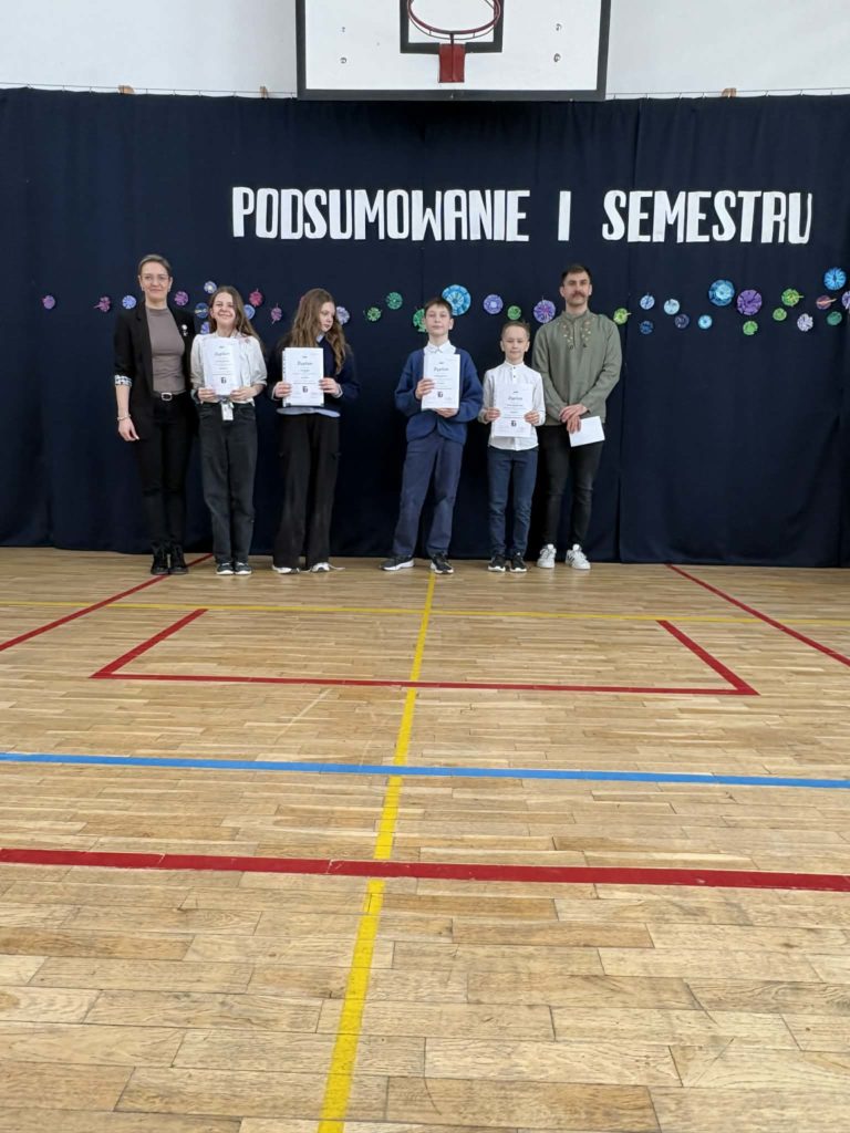 Wyróżnieni uczniowie za konkursy historyczno-plastyczne trzymają dyplomy i nagrody rzeczowe