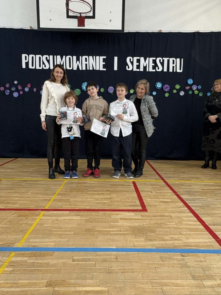 Wyróżnieni uczniowie za konkursy z matematyki trzymają dyplomy i nagrody rzeczowe