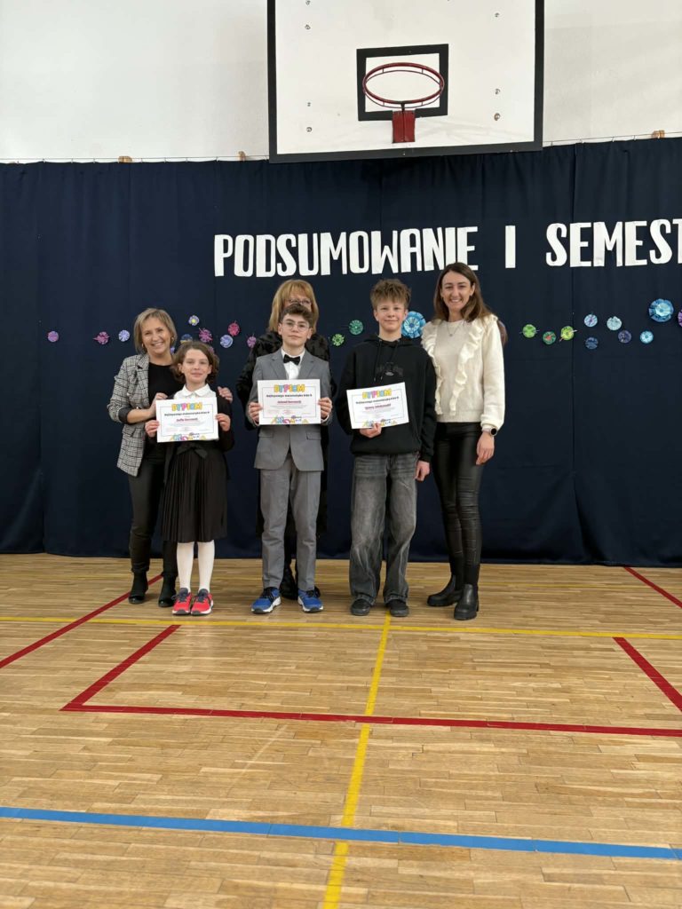 Wyróżnieni uczniowie za konkursy z matematyki trzymają dyplomy i nagrody rzeczowe