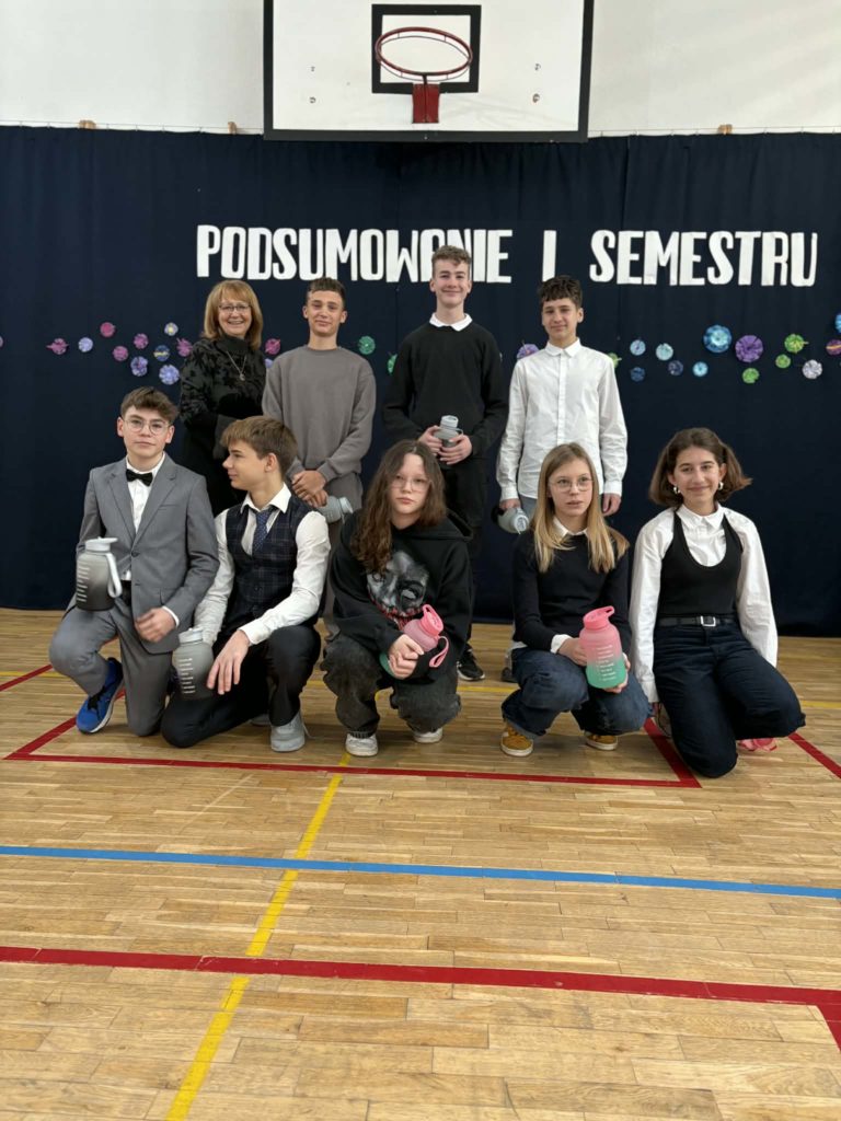 Wyróżnieni uczniowie za konkursy sportowe trzymają dyplomy i nagrody rzeczowe