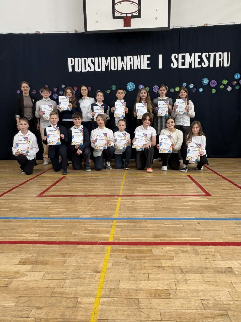 Na sali gimnastycznej stoi grupa wyróżnionych uczniów wraz z dyrekcją, wychowawcami oraz nauczycielami przedmiotowymi, za wysokie osiągnięcia w nauce i bardzo dobre lub wzorowe zachowanie