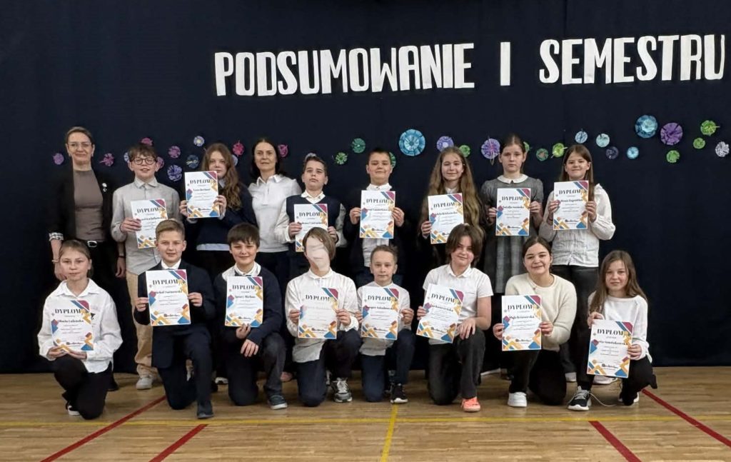 Na sali gimnastycznej stoi grupa wyróżnionych uczniów wraz z dyrekcją, wychowawcami oraz nauczycielami przedmiotowymi, za wysokie osiągnięcia w nauce i bardzo dobre lub wzorowe zachowanie