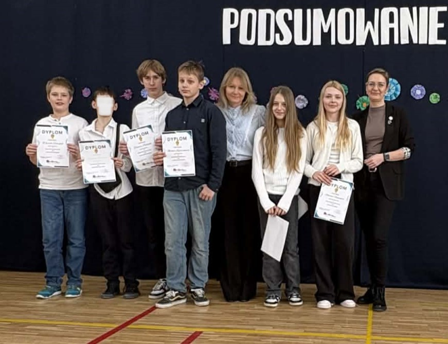 Na sali gimnastycznej stoi grupa wyróżnionych uczniów wraz z dyrekcją, wychowawcami oraz nauczycielami przedmiotowymi, za wysokie osiągnięcia w nauce i bardzo dobre lub wzorowe zachowanie