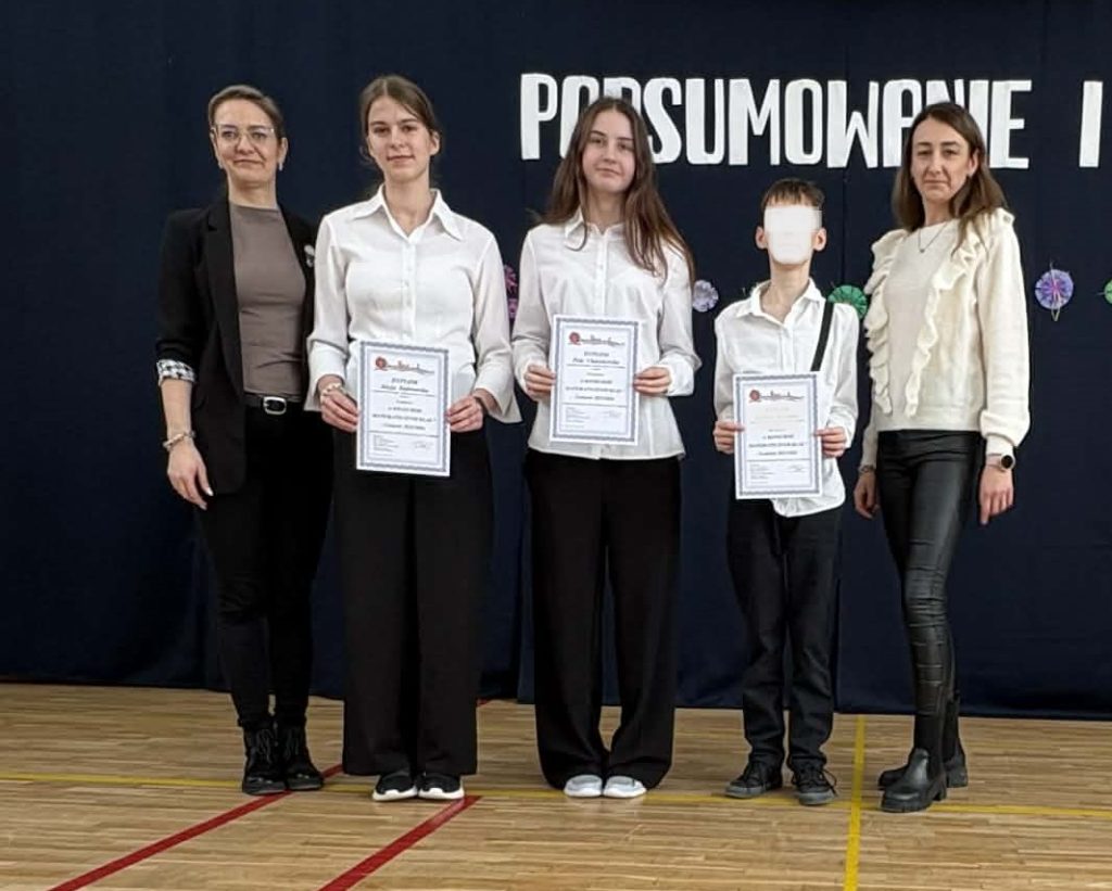Wyróżnieni uczniowie za konkursy z matematyki trzymają dyplomy i nagrody rzeczowe
