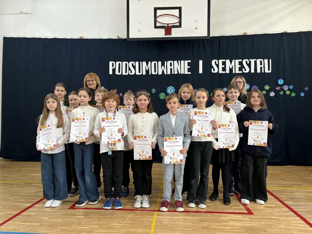 Na sali gimnastycznej stoi grupa wyróżnionych uczniów wraz z dyrekcją, wychowawcami oraz nauczycielami przedmiotowymi, za wysokie osiągnięcia w nauce i bardzo dobre lub wzorowe zachowanie