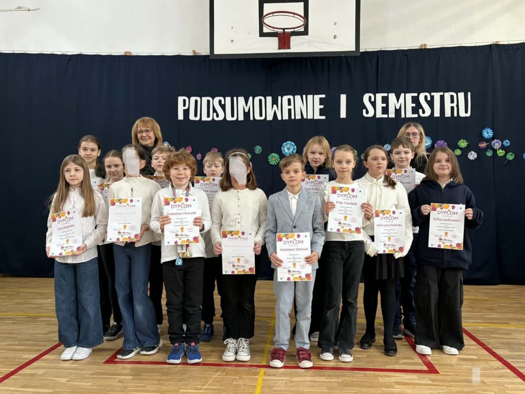 Na sali gimnastycznej stoi grupa wyróżnionych uczniów wraz z dyrekcją, wychowawcami oraz nauczycielami przedmiotowymi, za wysokie osiągnięcia w nauce i bardzo dobre lub wzorowe zachowanie