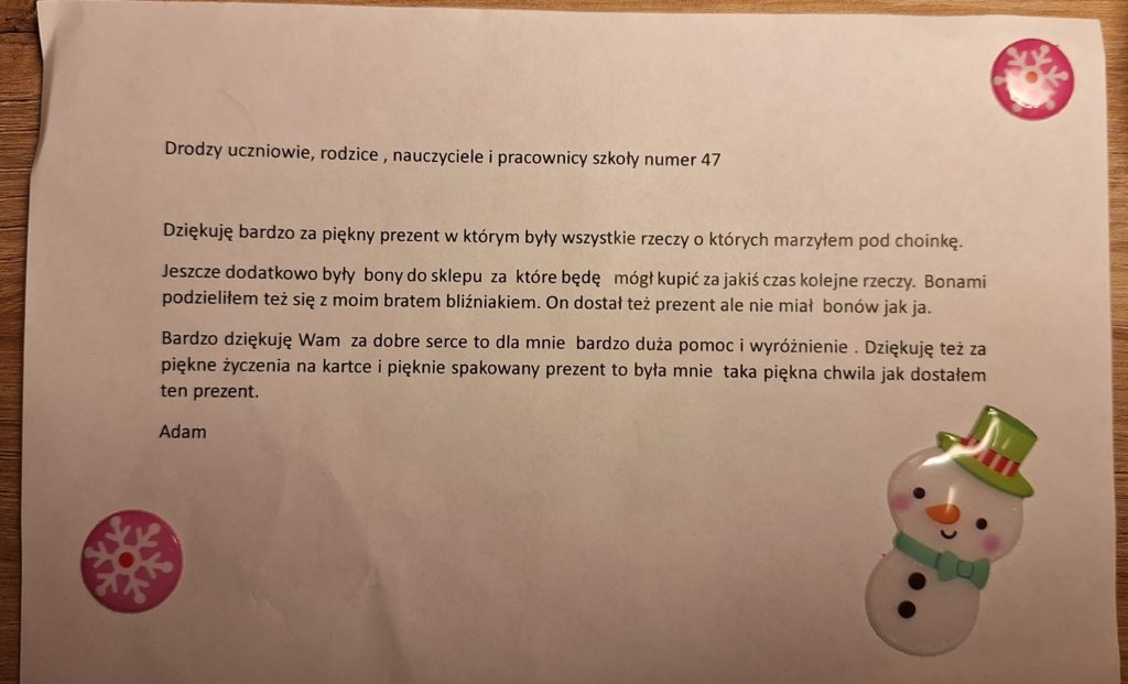 Biała kartka papieru z wydrukowanym tekstem podziękowania podpisanym imieniem Adam. Drodzy uczniowie, rodzice, nauczyciele i pracownicy szkoły numer 47Dziękuję bardzo za piękny prezent, w którym były wszystkie rzeczy, o których marzyłem pod choinkę. Jeszcze dodatkowo były bony do sklepu za które będę mógł kupić za jakiś czas kolejne rzeczy. Bonami podzieliłem też się z moim bratem bliźniakiem. On dostał też prezent, ale nie miał bonów jak ja. Bardzo dziękuję Wam za dobre serce to dla mnie bardzo duża pomoc i wyróżnienie. Dziękuję też za piękne życzenia na kartce i pięknie spakowany prezent to była mnie taka piękna chwila jak dostałem ten prezent. Adam