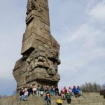 Uczniowie klasy 1c siedzący na schodach pod Pomnik Obrońców Wybrzeża.