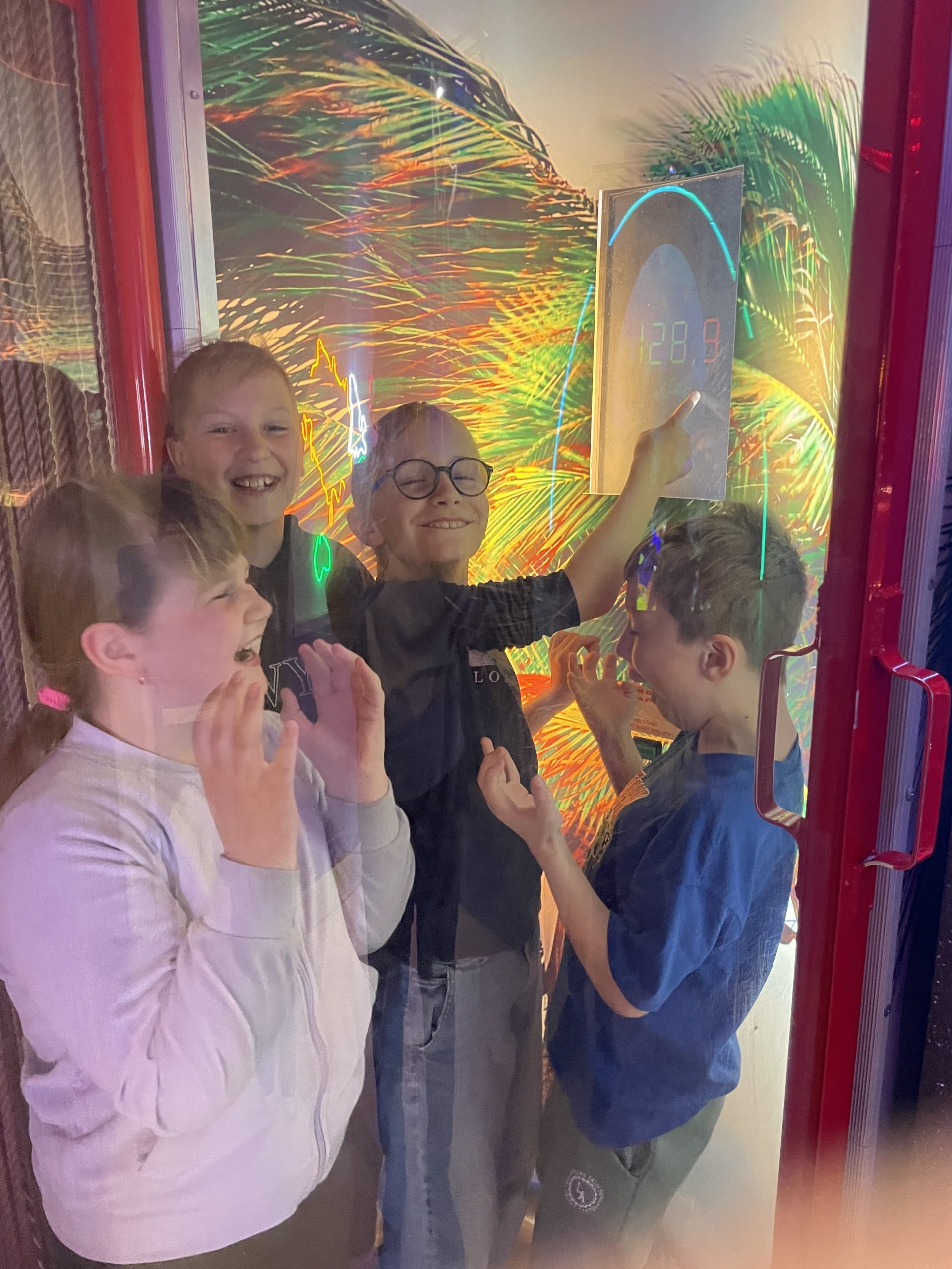 czworo uczniów stoi w symulatorze huraganu.