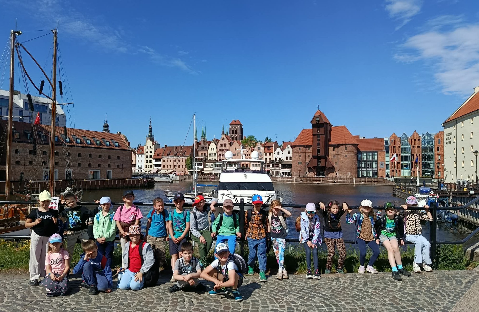 Na tle nabrzeża Motławy i mariny stoi ustawiona w szeregu klasa 1c.