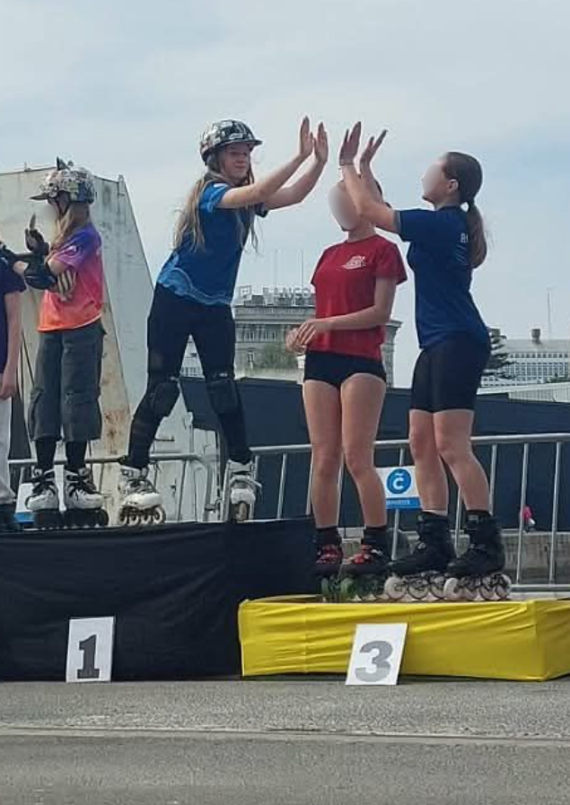 Młodzi rolkarze stoją na podium podczas ceremonii wręczenia nagród, świętując sukcesy w zawodach