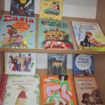 Fotografia okładek książek ułożonych na witrynie bibliotecznej w sektorze nowości.